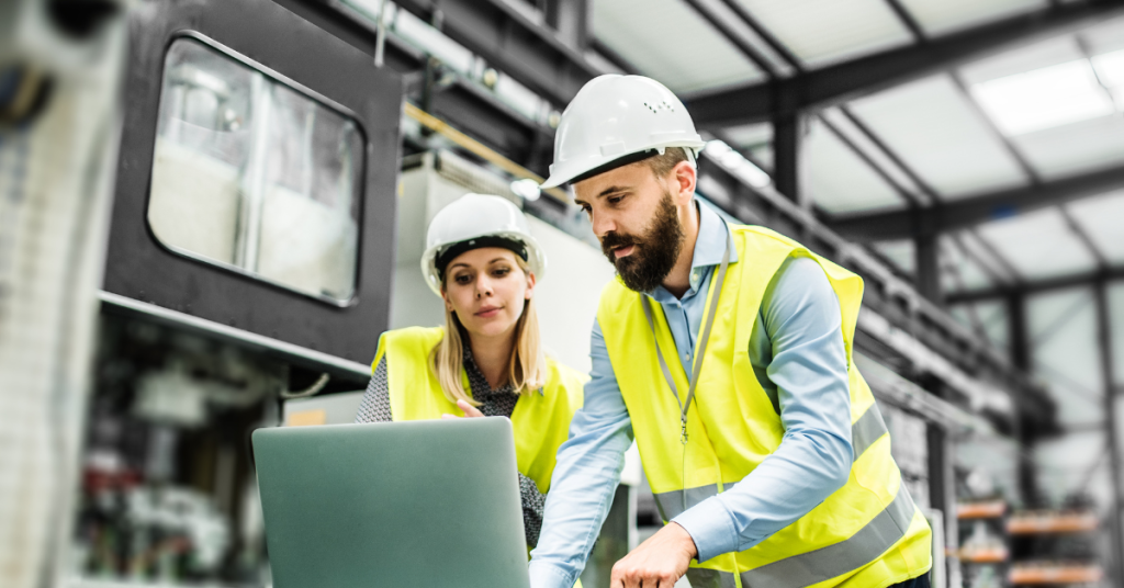 Manufacturing workers looking at laptop in a plant